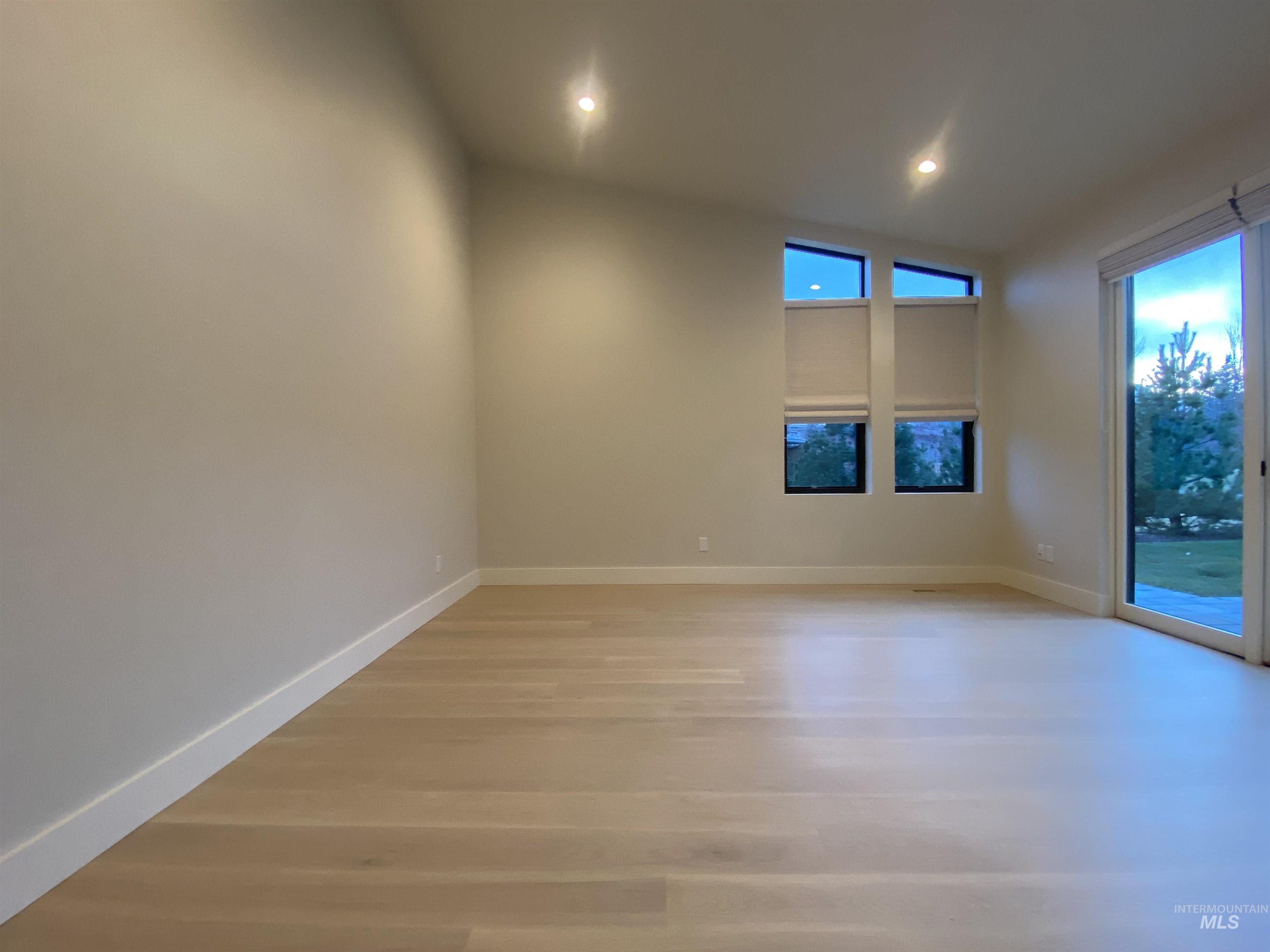 Spare room featuring light wood-style flooring, recessed lighting, and lofted ceiling