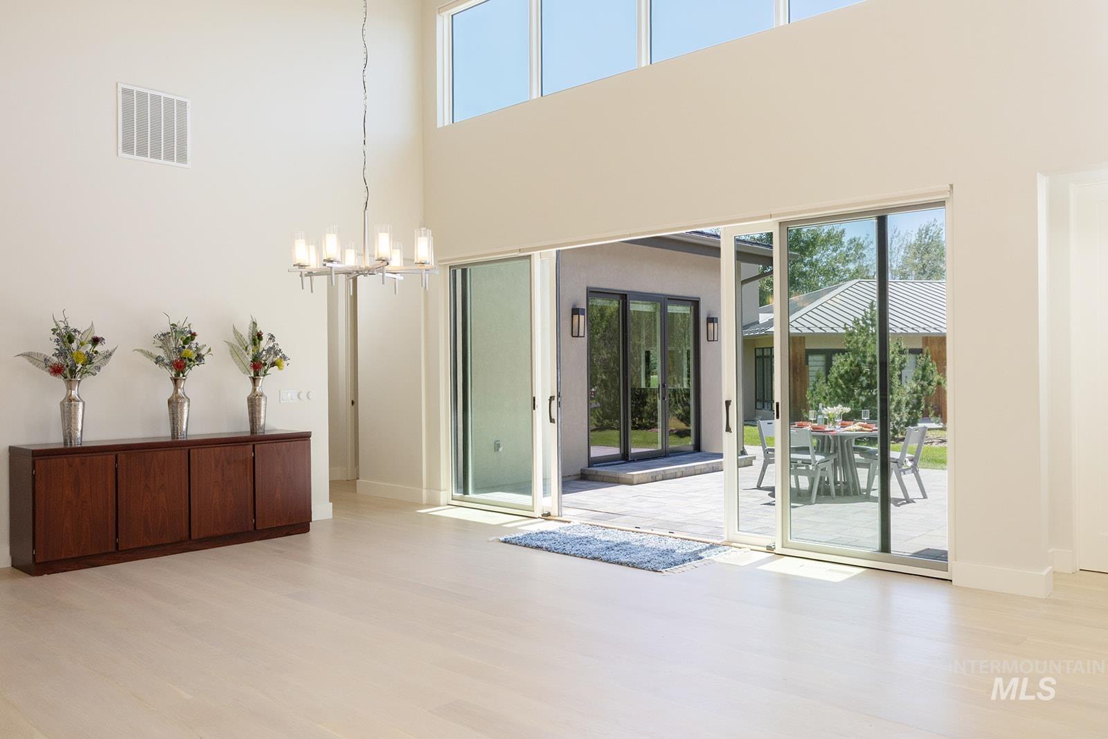 Doorway featuring light wood-type flooring and a chandelier