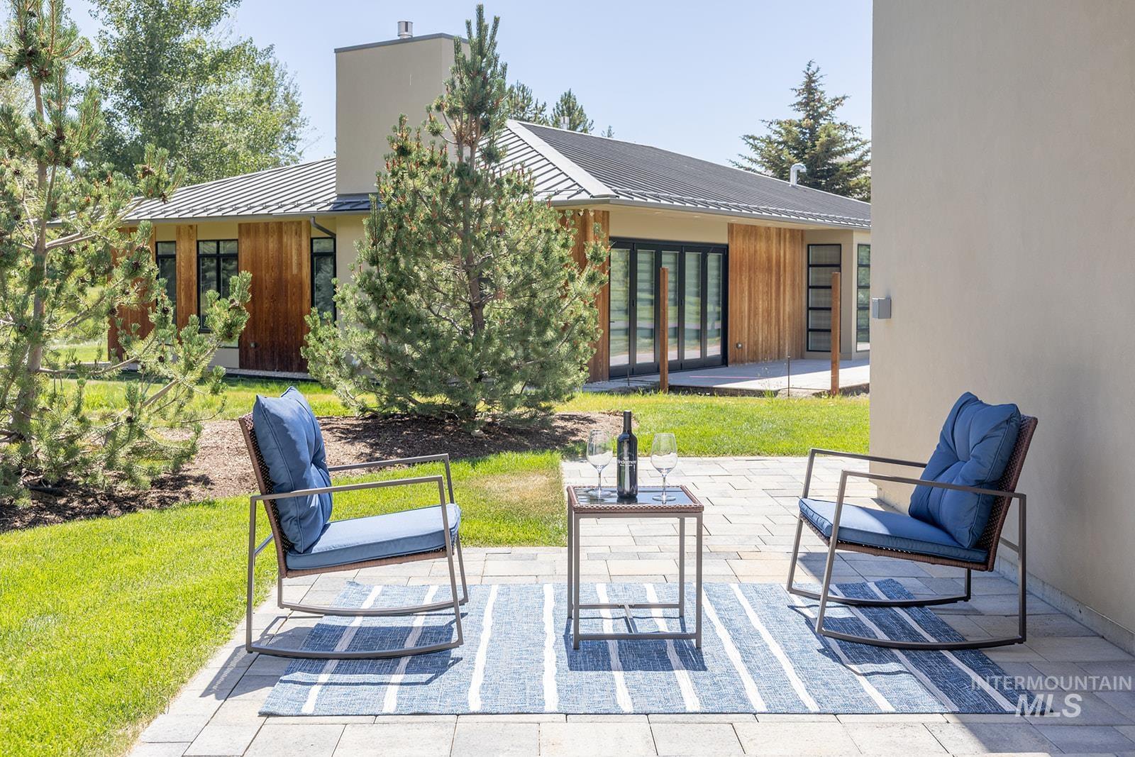 Rear view of property with a standing seam roof, a metal roof, and a patio area