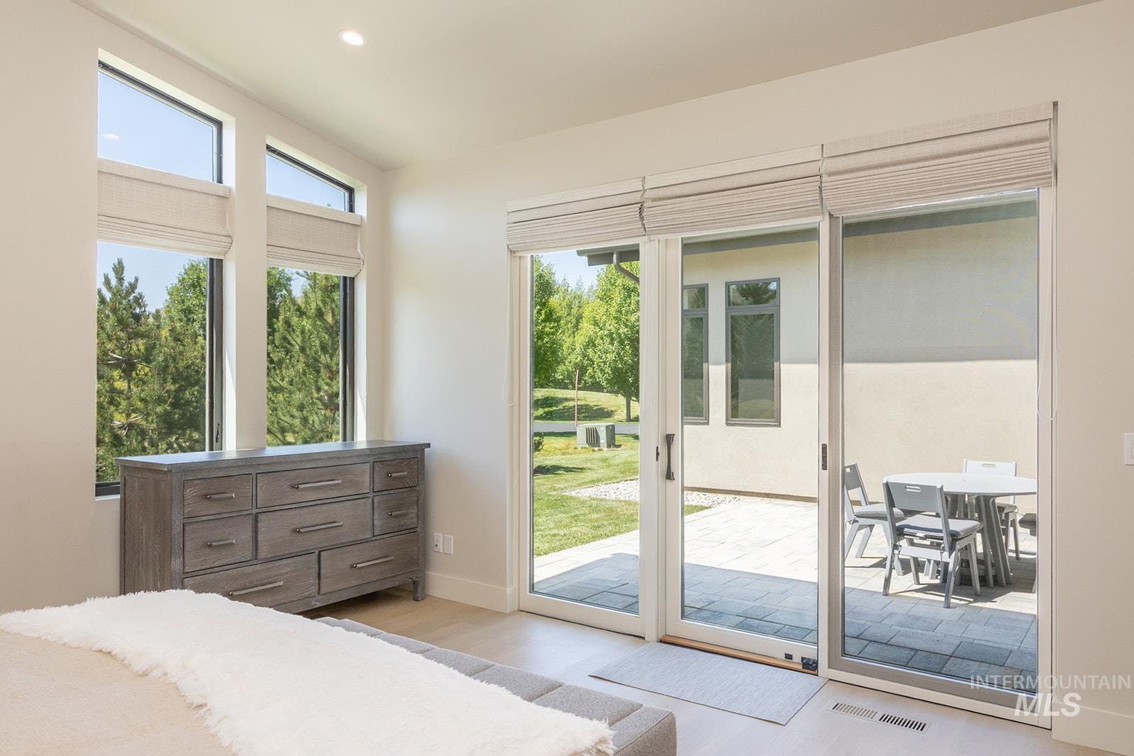 Bedroom featuring access to exterior, light wood finished floors, and recessed lighting
