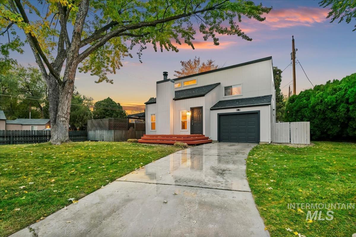 Modern home with driveway, a garage, and a chimney