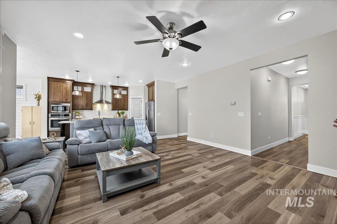 Living area with recessed lighting, dark wood-style flooring, and ceiling fan