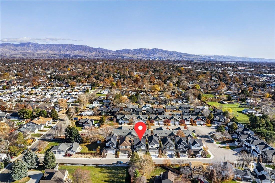 Aerial view of property and surrounding area with a mountain backdrop and nearby suburban area