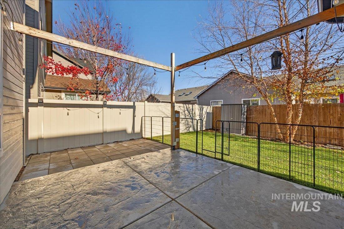 Fenced backyard featuring a patio and a gate