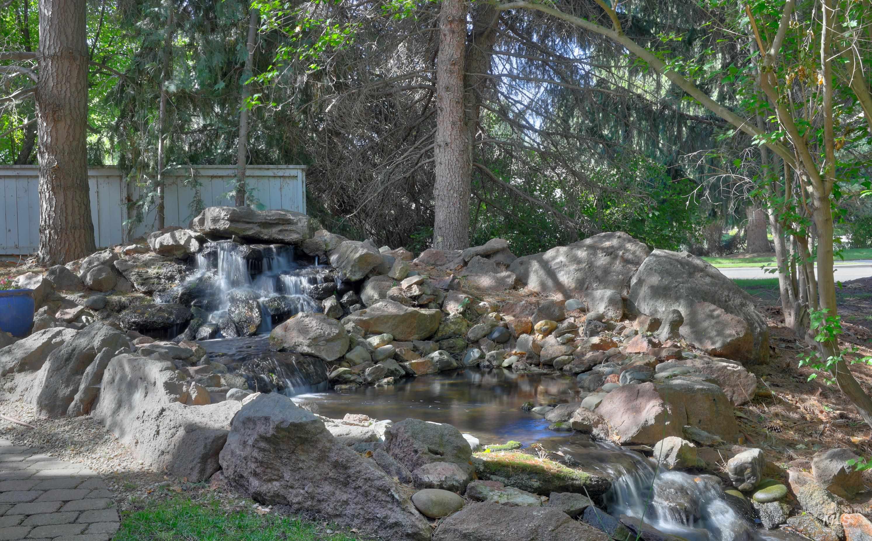 Water feature with a multi-tiered waterfall and natural rock landscaping