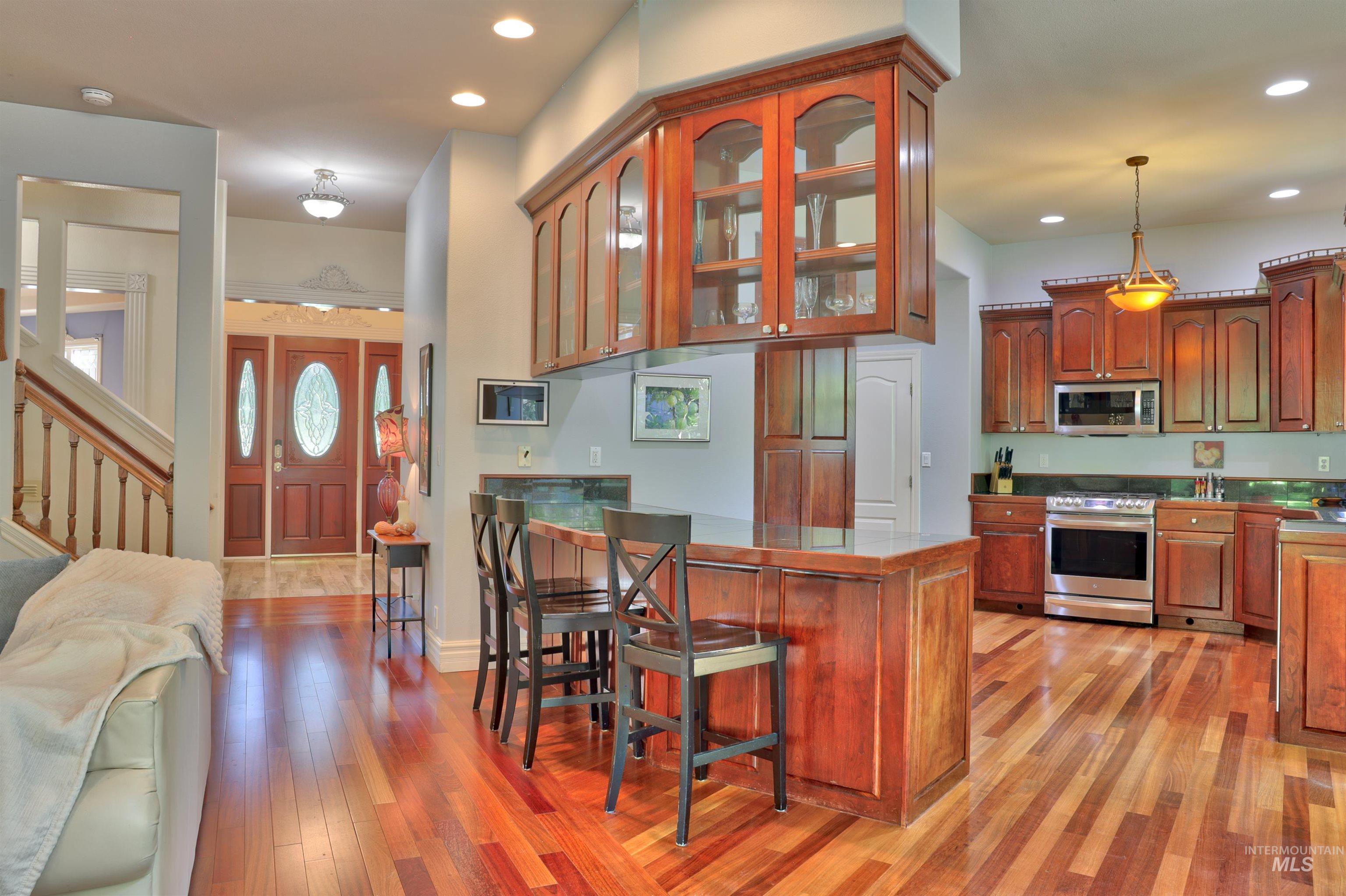 Kitchen featuring rich wood cabinetry, stainless steel appliances, and a central island with integrated seating