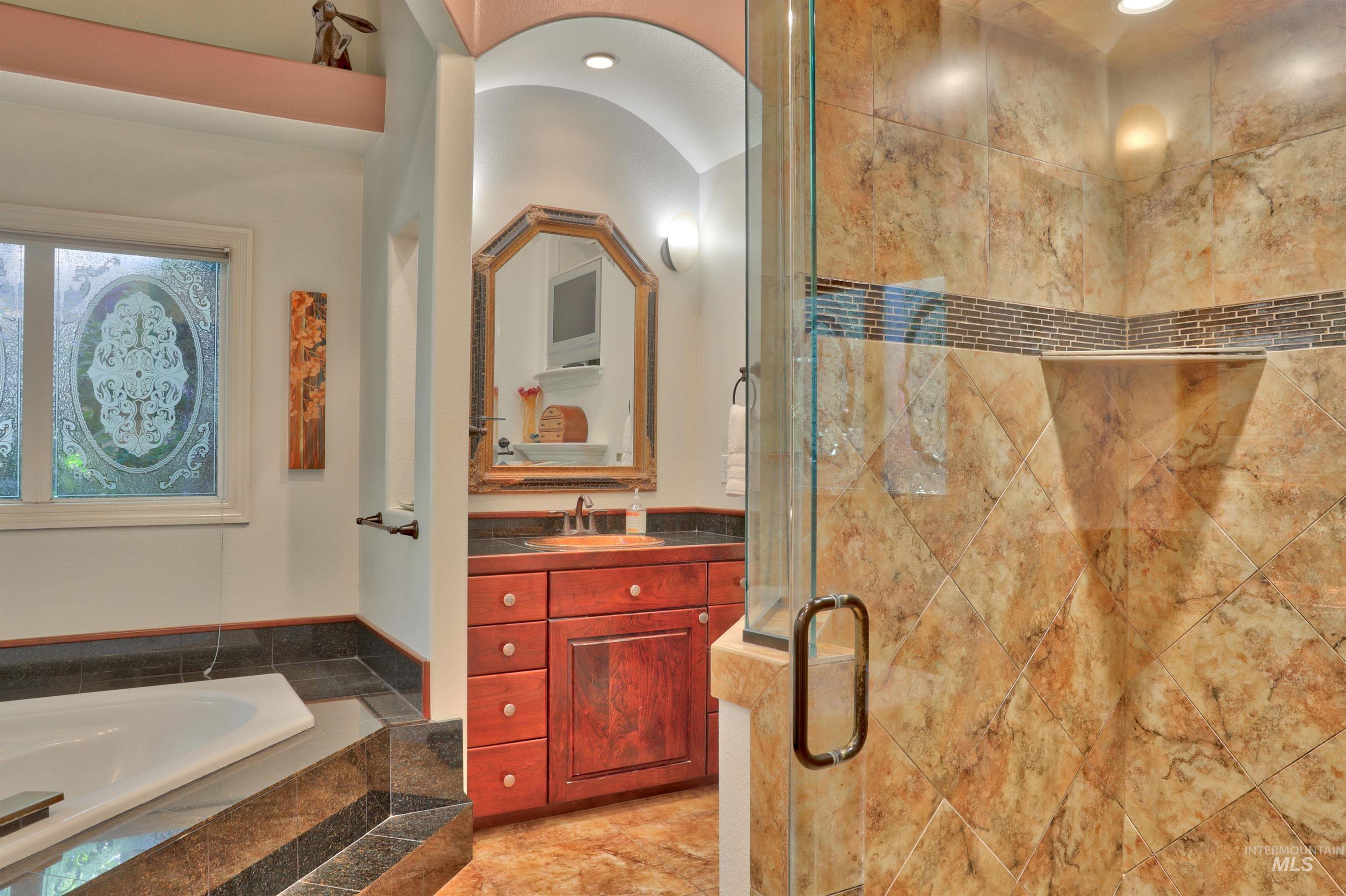 Glass-enclosed shower with tiled walls and a built-in shelf