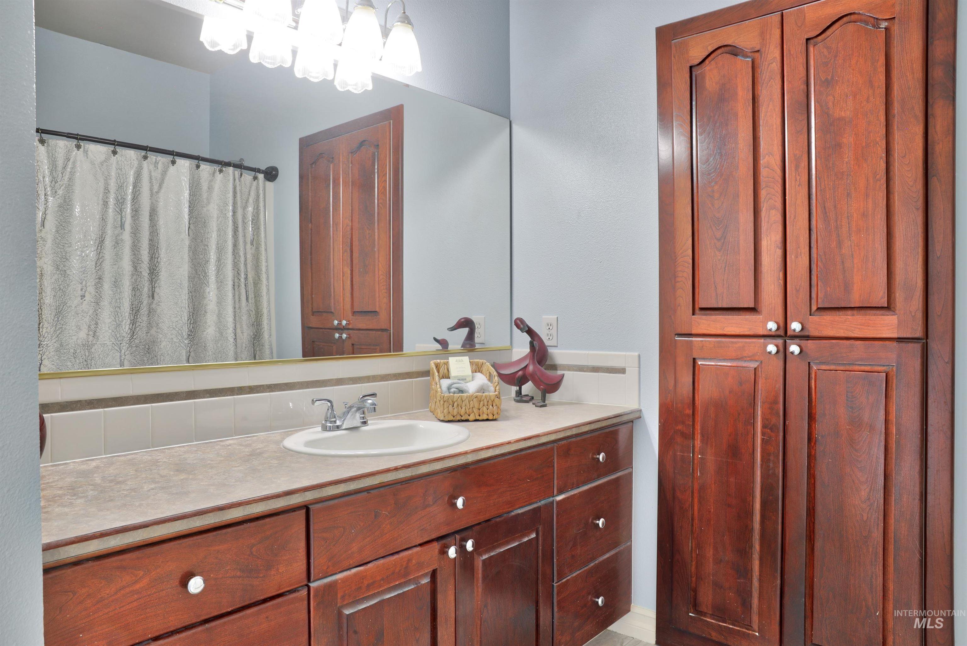 Wood-finish cabinetry and built-in storage tower featuring white knobs