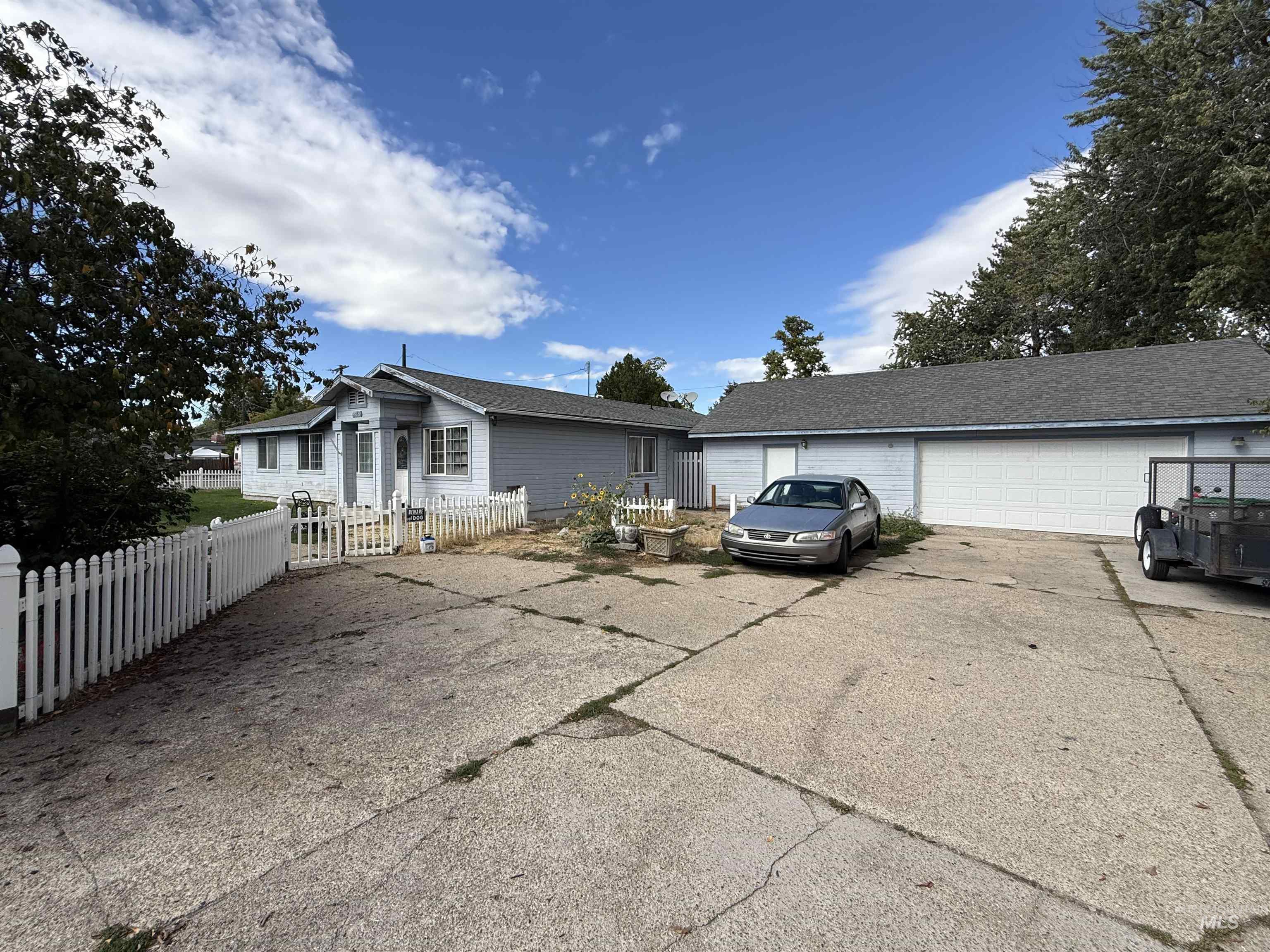 View of front of house with an outdoor structure, a fenced front yard, and a garage