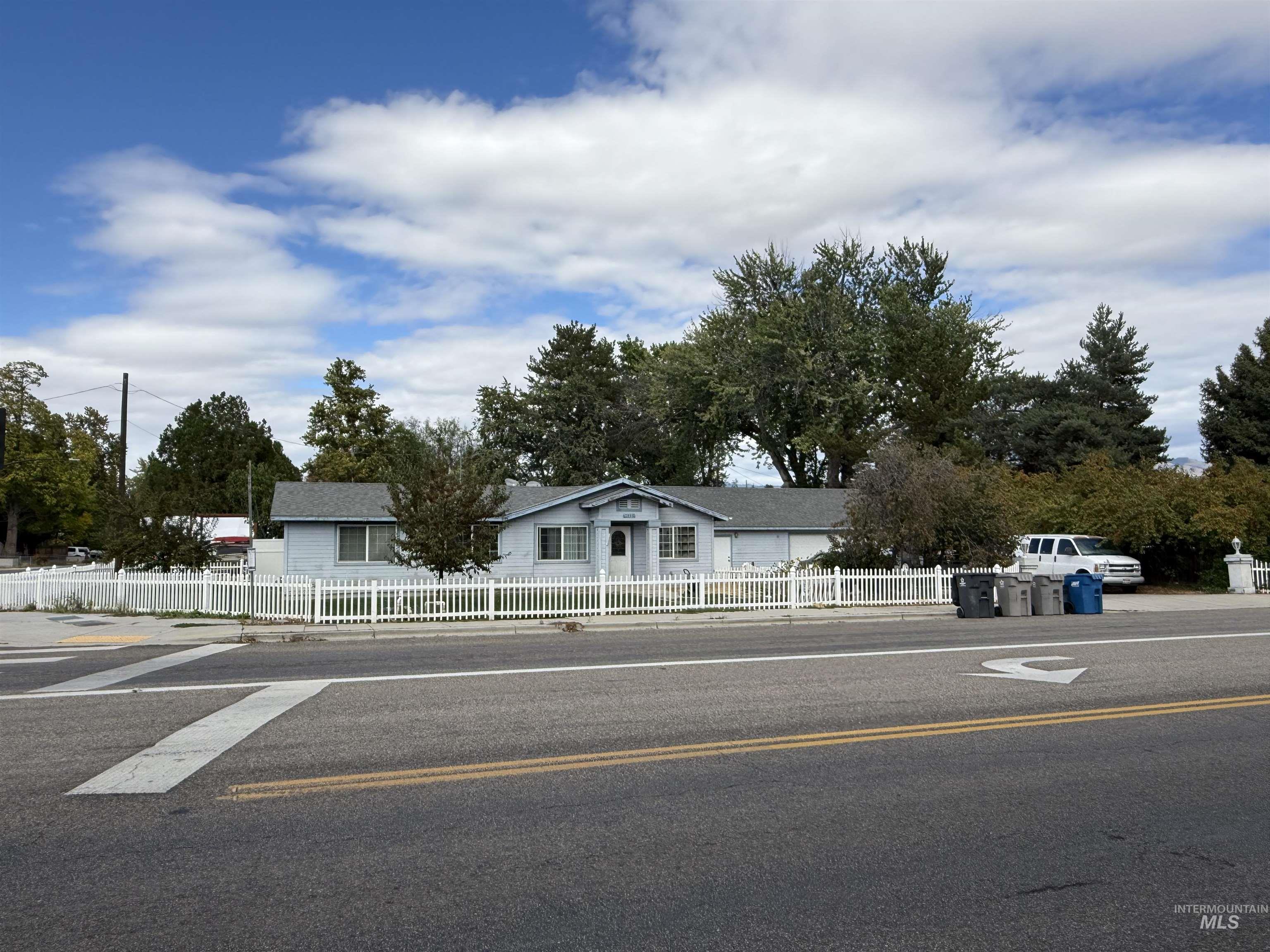 View of asphalt road featuring sidewalks and curbs