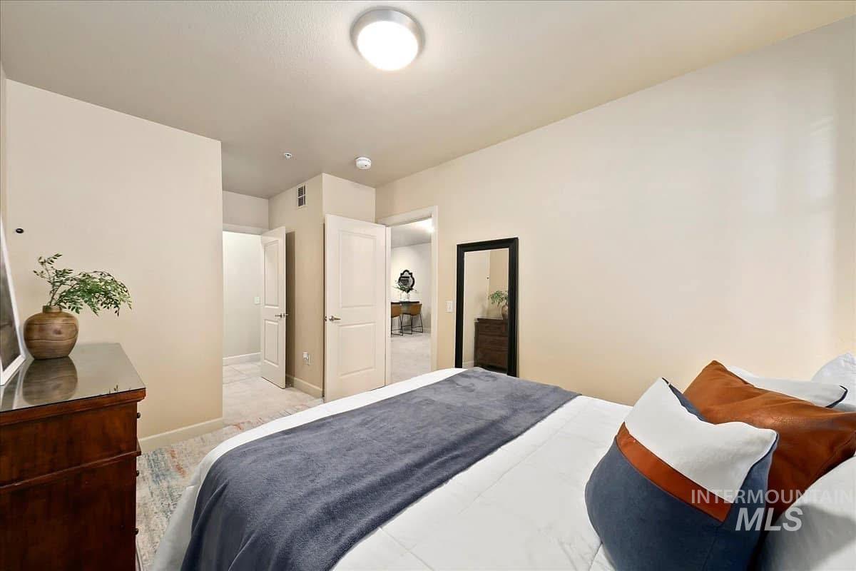 Bedroom featuring baseboards and light carpet