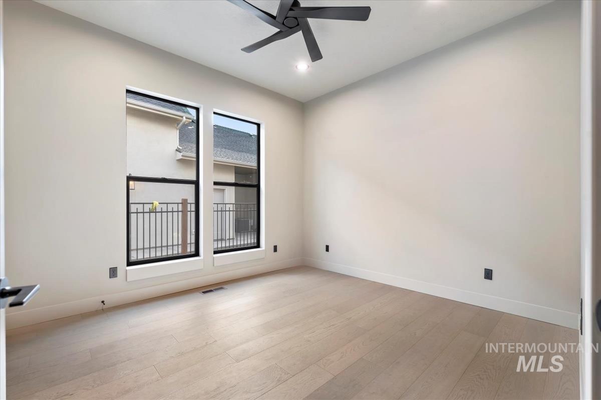 Empty room featuring light wood-type flooring, ceiling fan, and recessed lighting