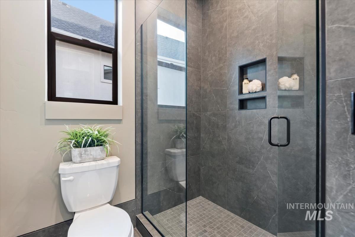 Full bathroom with toilet and a shower stall