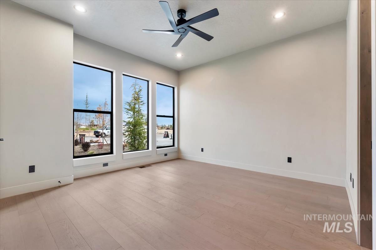 Unfurnished room featuring light wood-style flooring, a ceiling fan, and recessed lighting