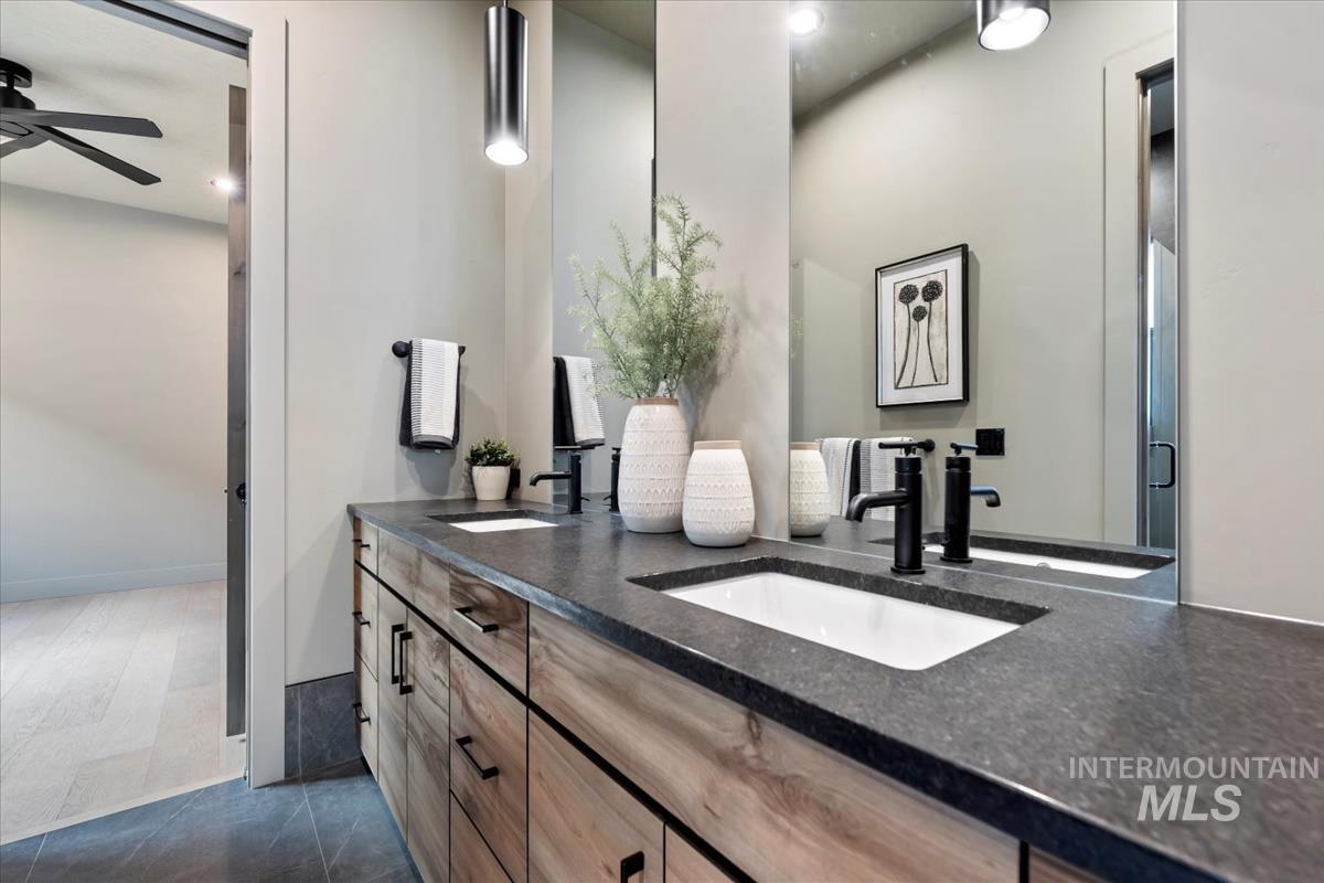 Bathroom featuring double vanity and dark tile patterned flooring