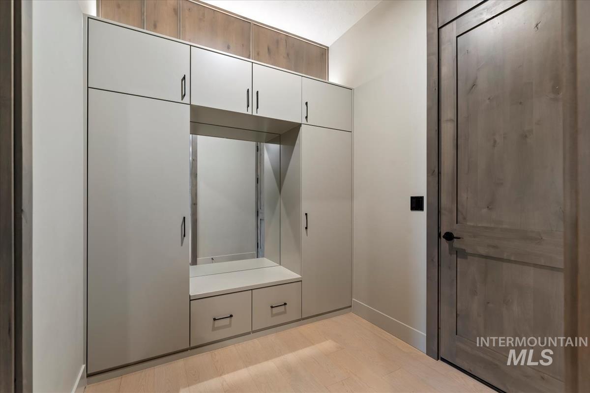 Mudroom featuring light wood finished floors and baseboards