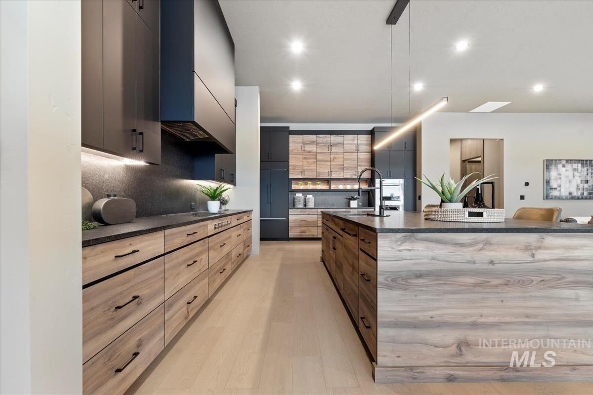 Kitchen featuring dark stone counters, modern cabinets, and recessed lighting