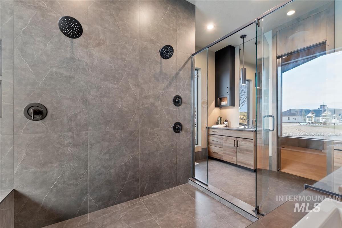 Full bathroom featuring vanity, a tile shower, and recessed lighting
