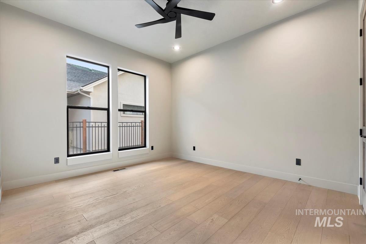 Empty room featuring light wood-style flooring, a ceiling fan, and recessed lighting