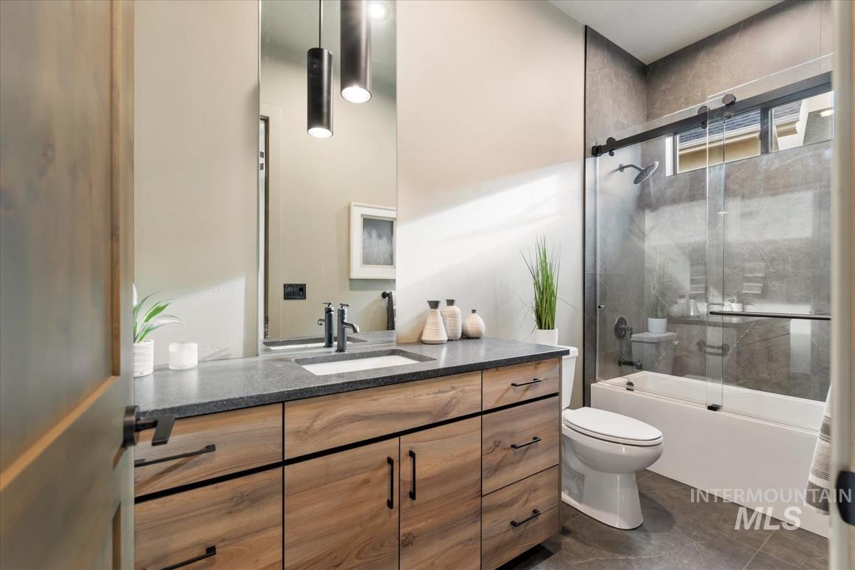 Bathroom with vanity and combined bath / shower with glass door