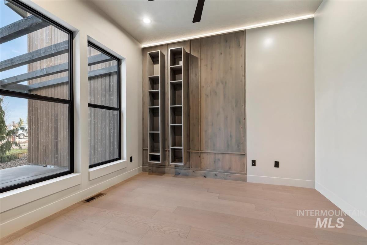 Unfurnished room featuring healthy amount of natural light, ceiling fan, wood finished floors, and recessed lighting