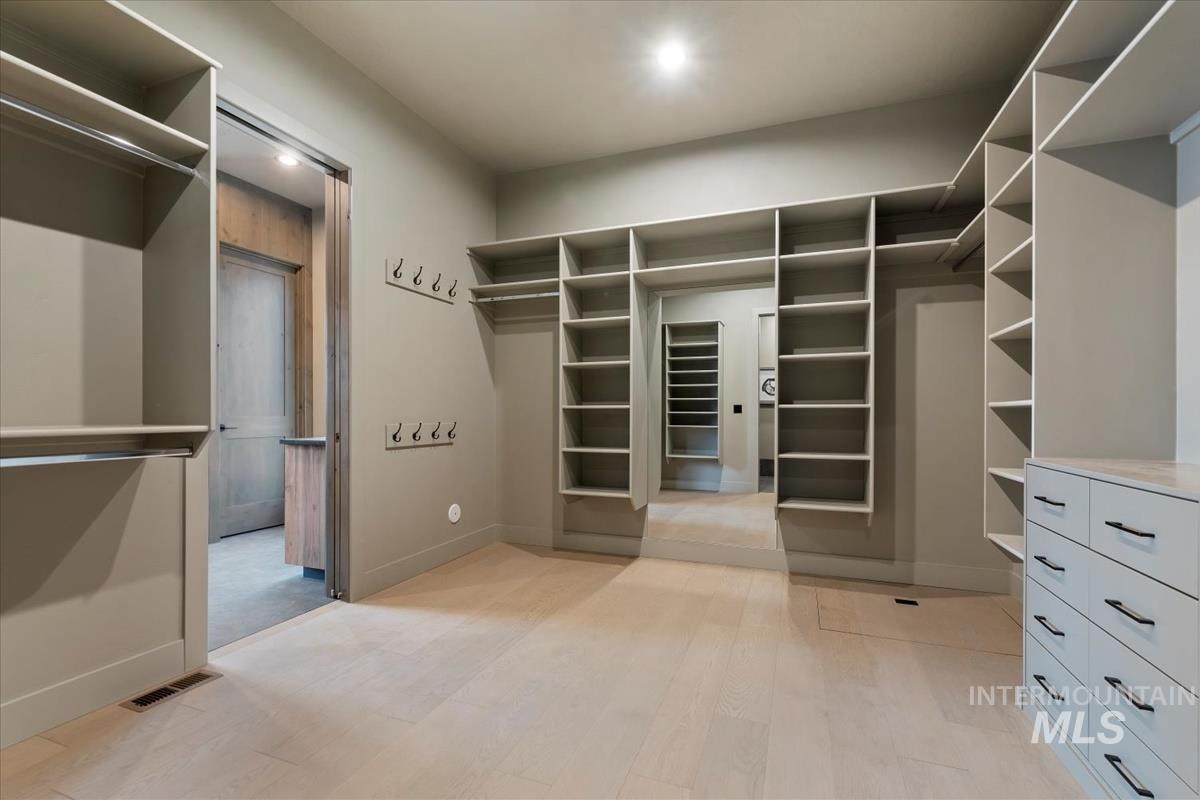 Walk in closet with light wood-style flooring