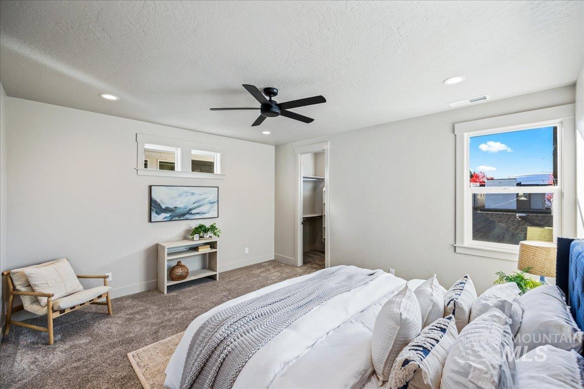 Bedroom featuring a walk in closet, carpet flooring, a textured ceiling, ceiling fan, and recessed lighting