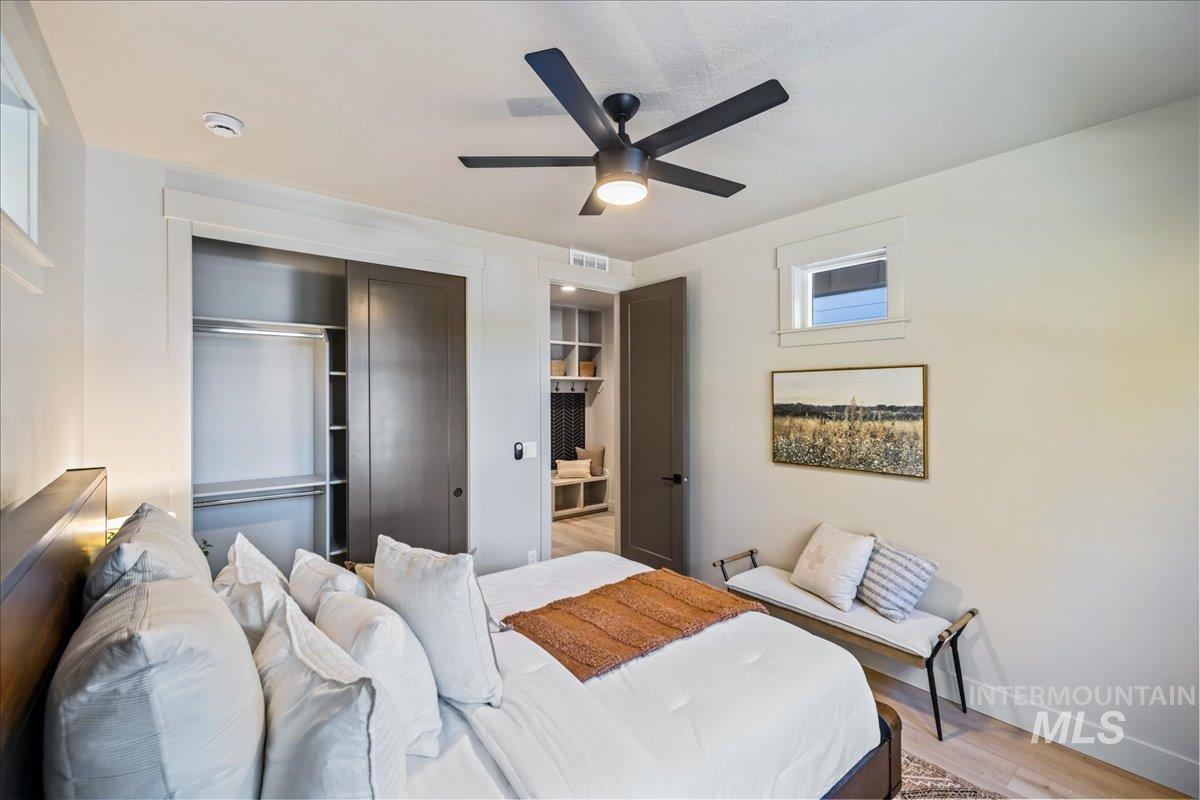 Bedroom featuring wood finished floors, a closet, and a ceiling fan