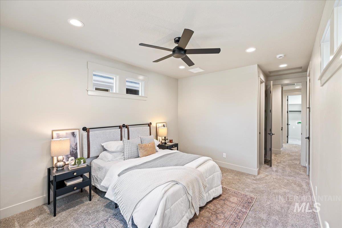 Bedroom with light carpet, ceiling fan, and recessed lighting