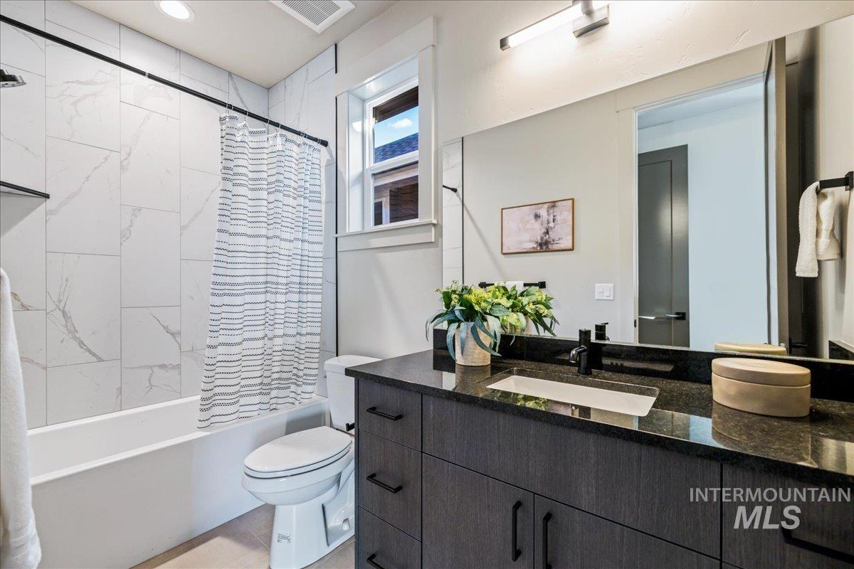 Full bath featuring shower / bath combination with curtain and vanity