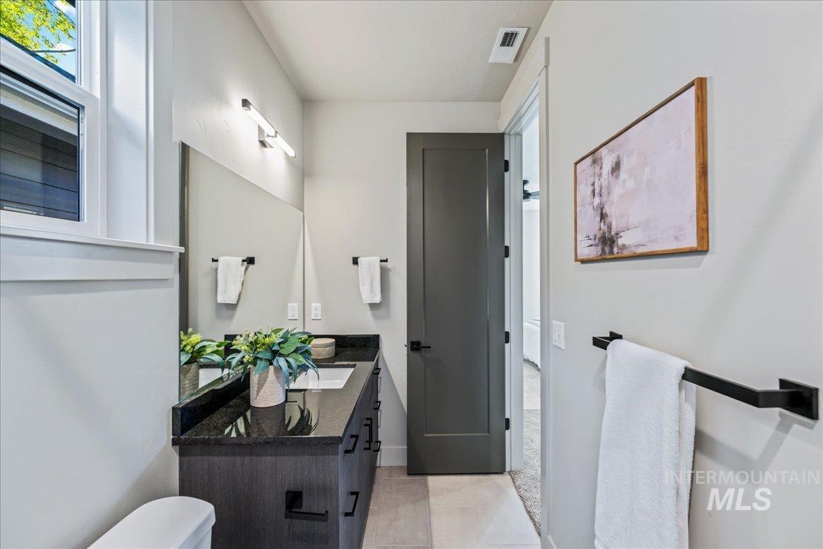 Half bathroom featuring vanity and light tile patterned floors