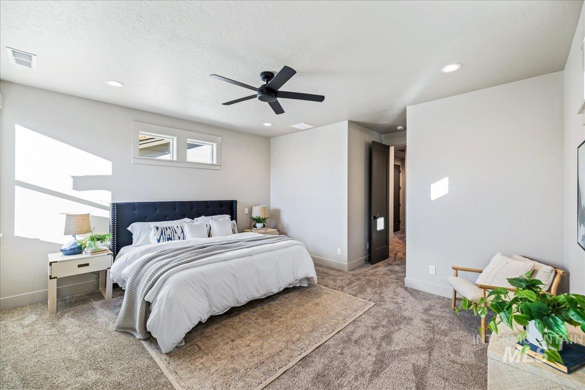 Carpeted bedroom featuring recessed lighting, ceiling fan, and a textured ceiling