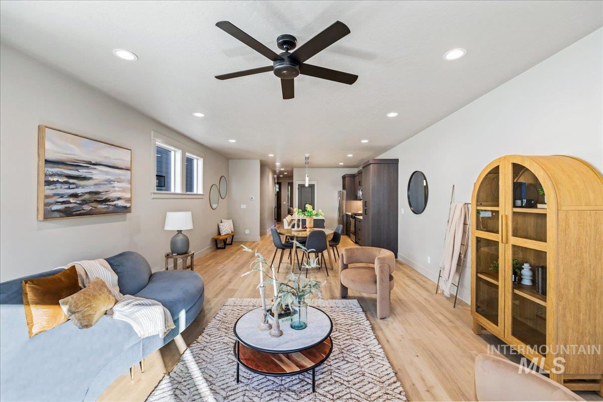Living room featuring light wood-type flooring, recessed lighting, and ceiling fan