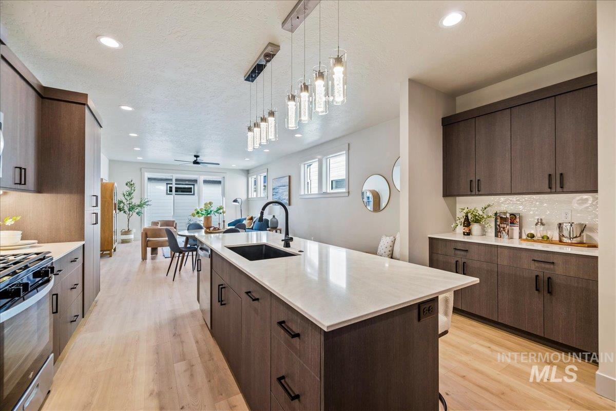 Kitchen with decorative backsplash, pendant lighting, light wood-type flooring, open floor plan, and recessed lighting