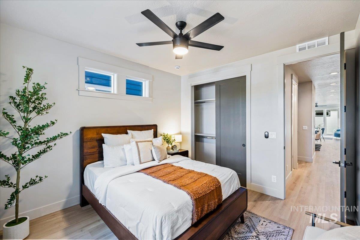 Bedroom featuring light wood-style flooring, a closet, and ceiling fan