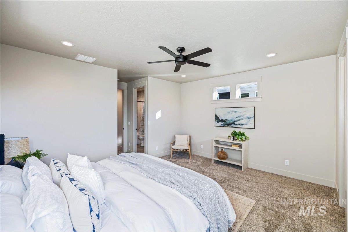 Carpeted bedroom with a ceiling fan and recessed lighting