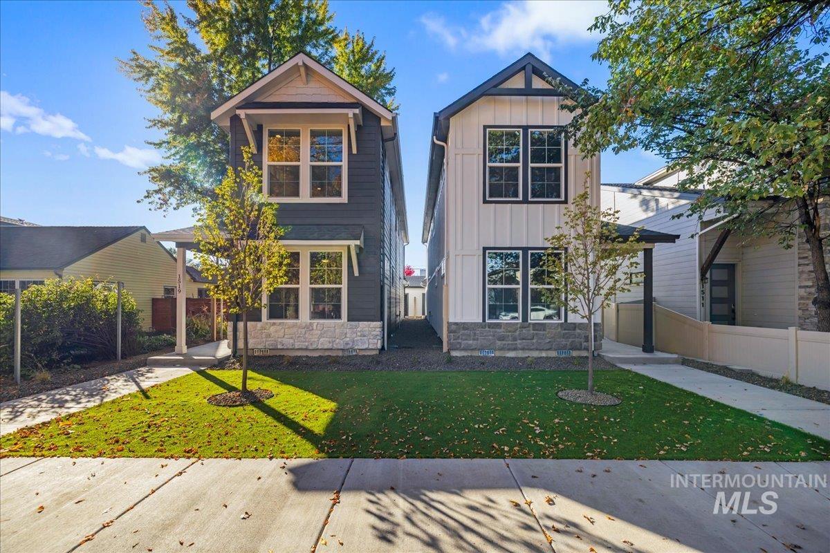 View of front of home featuring board and batten siding, stone siding, and a front yard