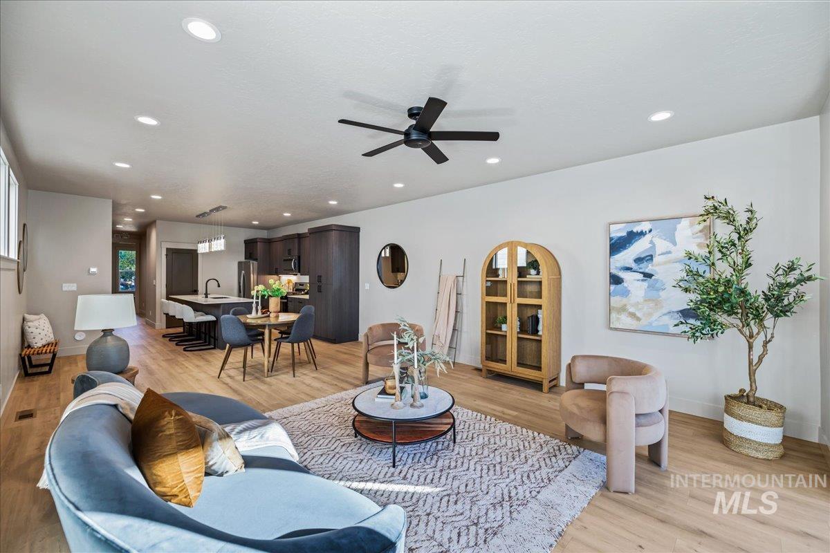 Living room with light wood-style floors, recessed lighting, and a ceiling fan