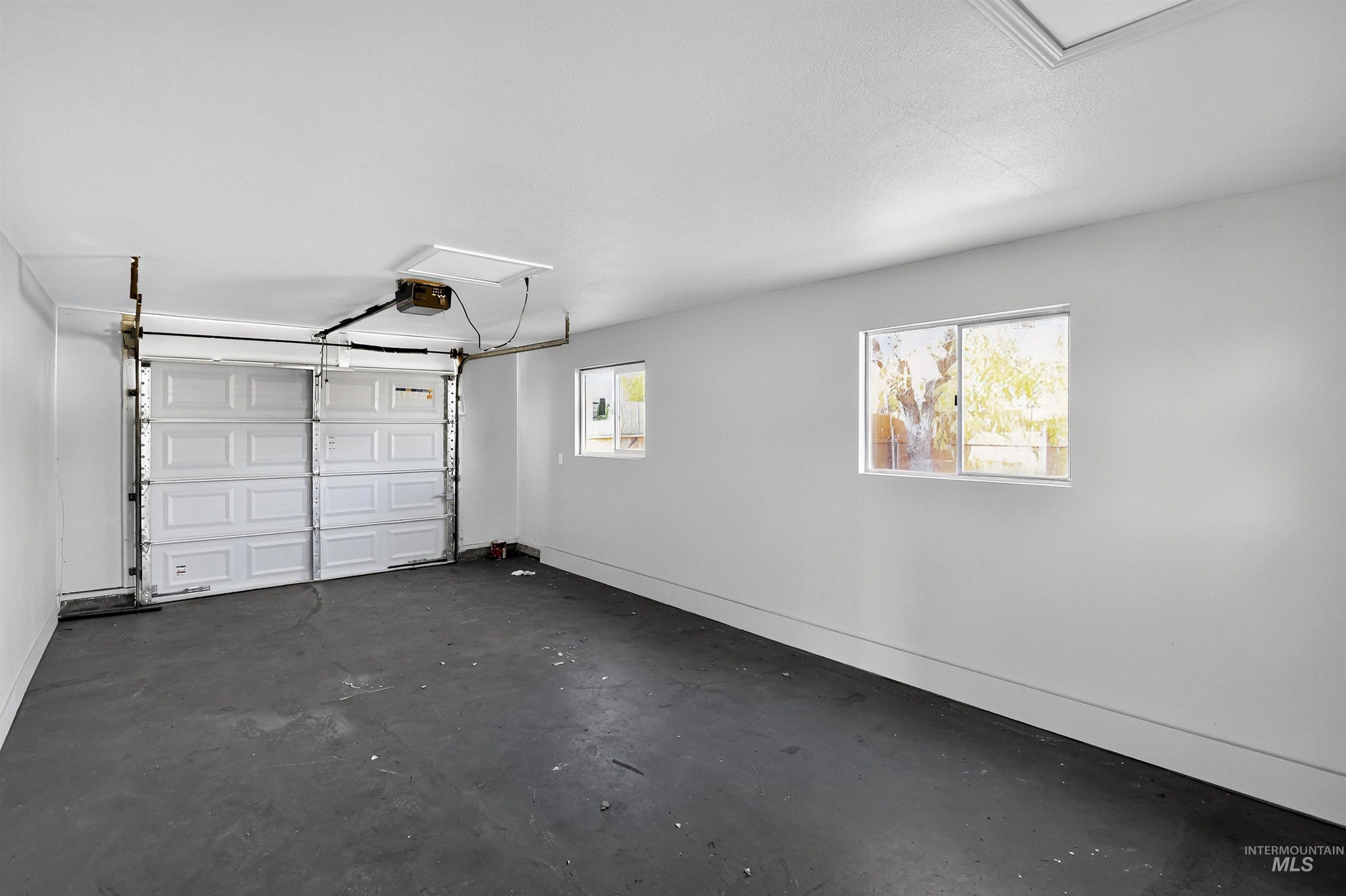 Garage with baseboards and a garage door opener