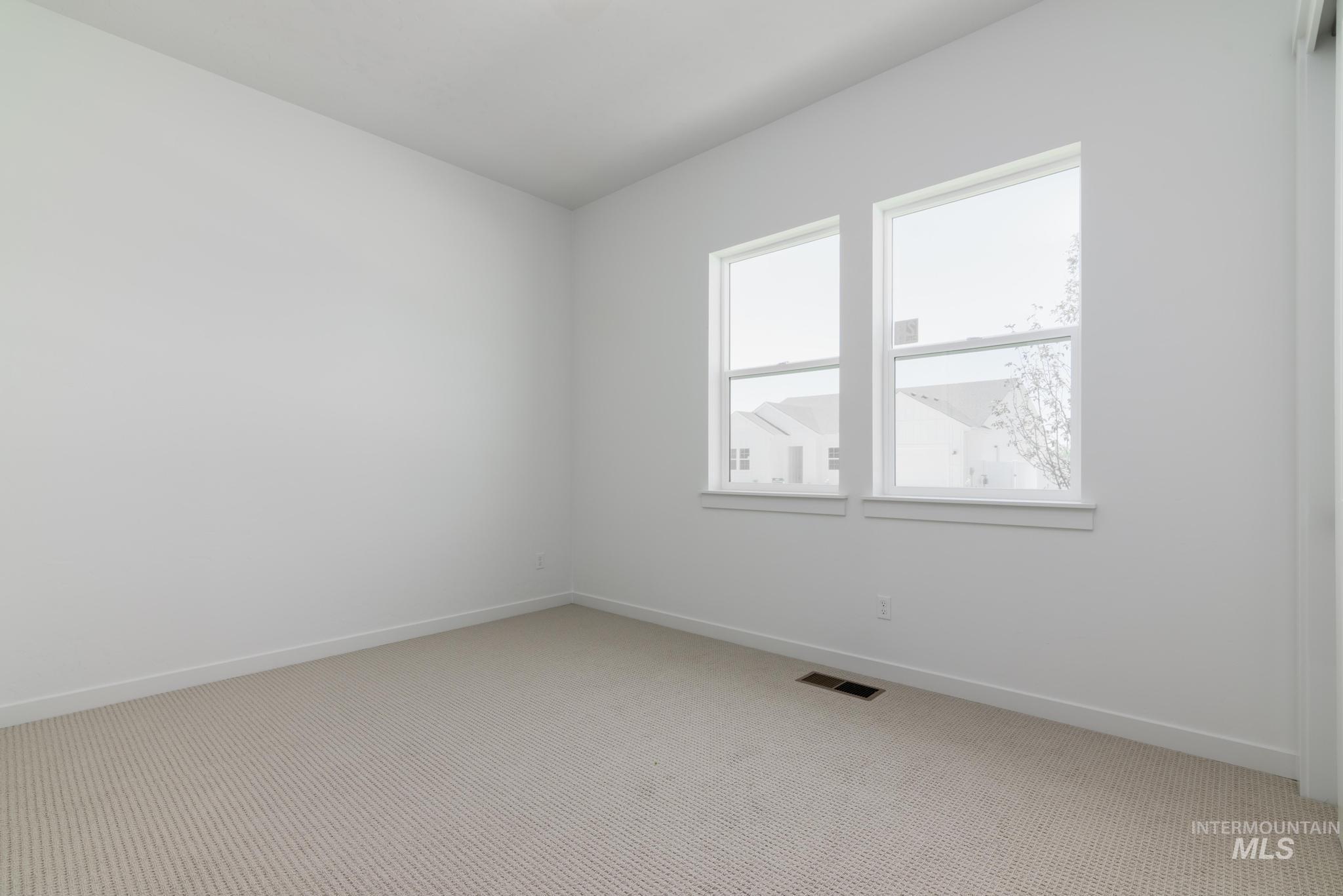 Unfurnished room featuring light colored carpet and baseboards
