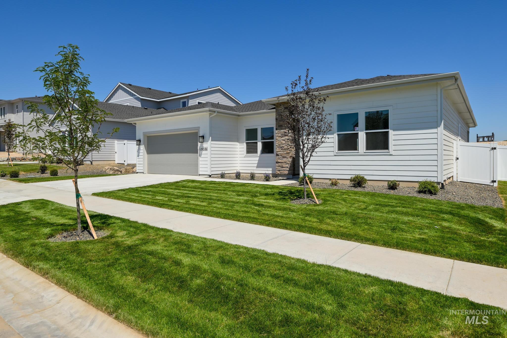 View of front facade featuring driveway, a garage, and a gate