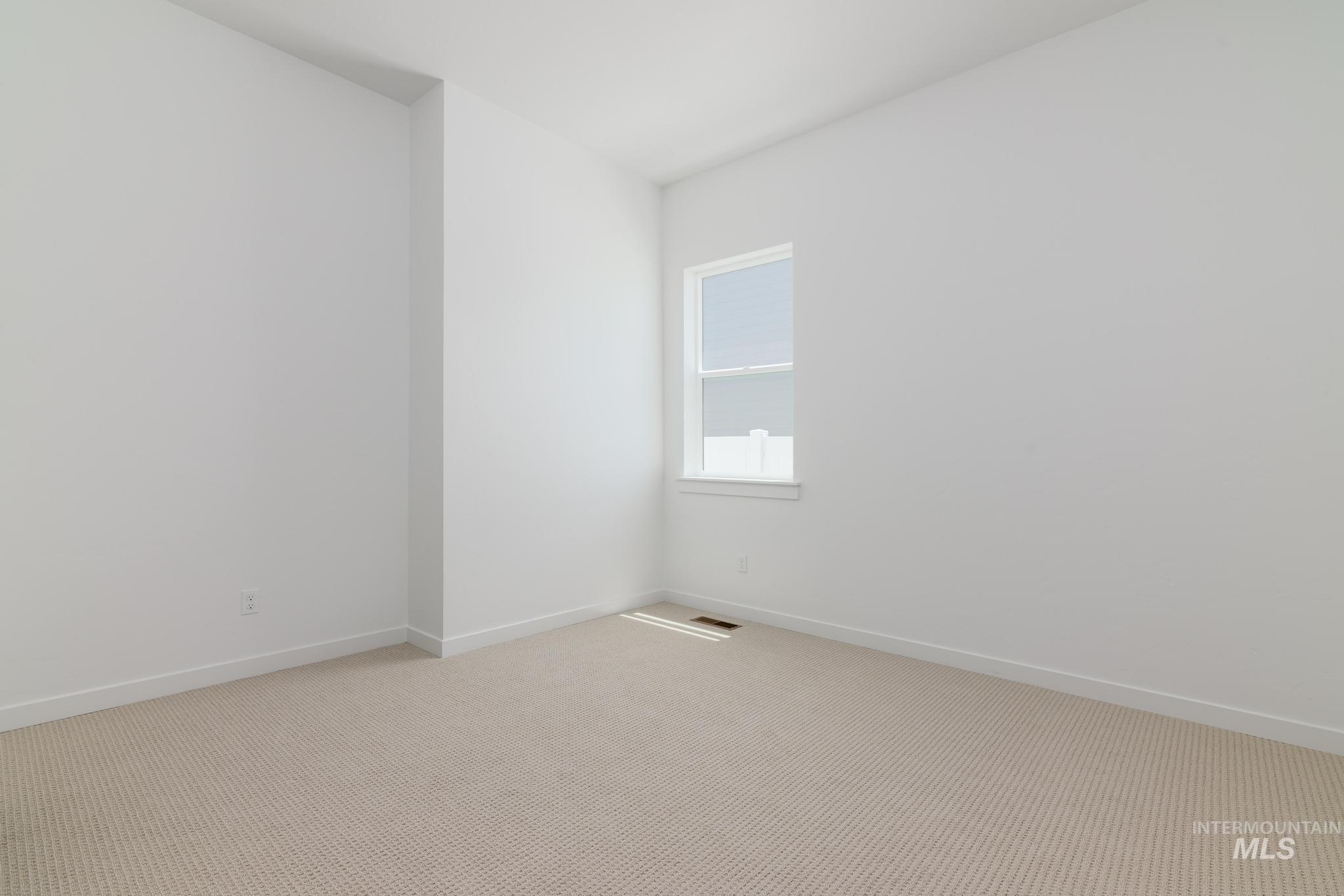 Unfurnished room with light colored carpet and baseboards