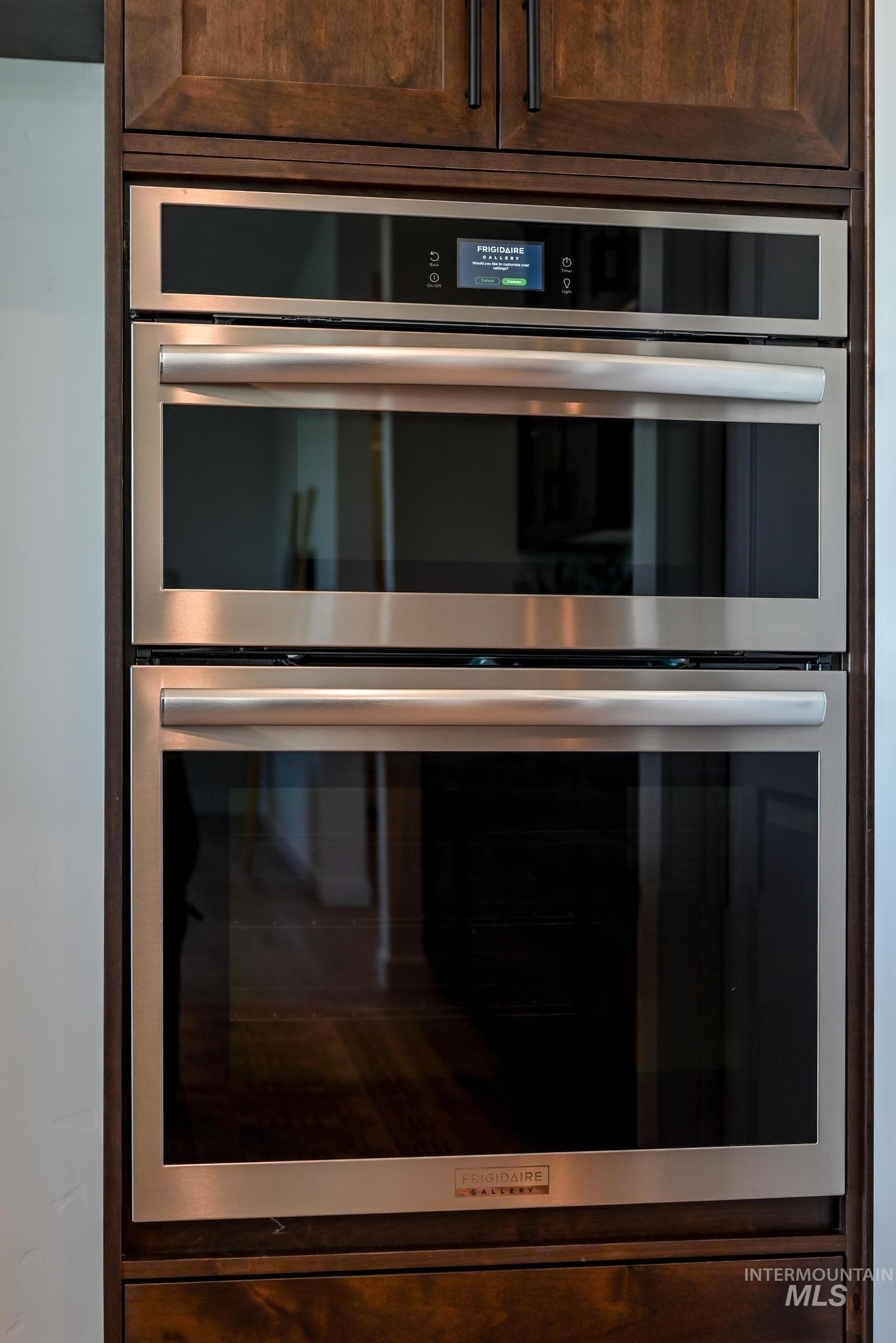 Kitchen view of double oven and dark brown cabinetry