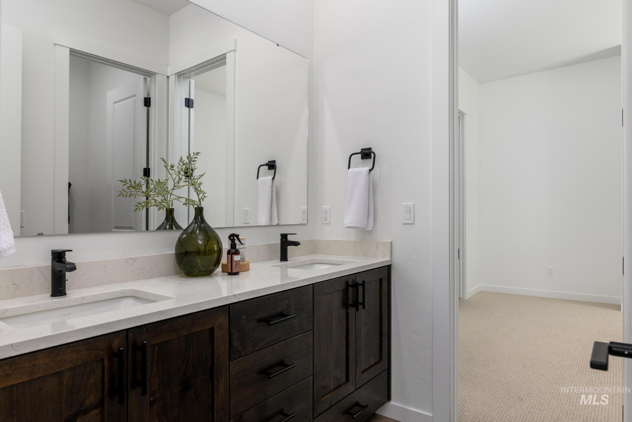 Full bathroom featuring double vanity and baseboards