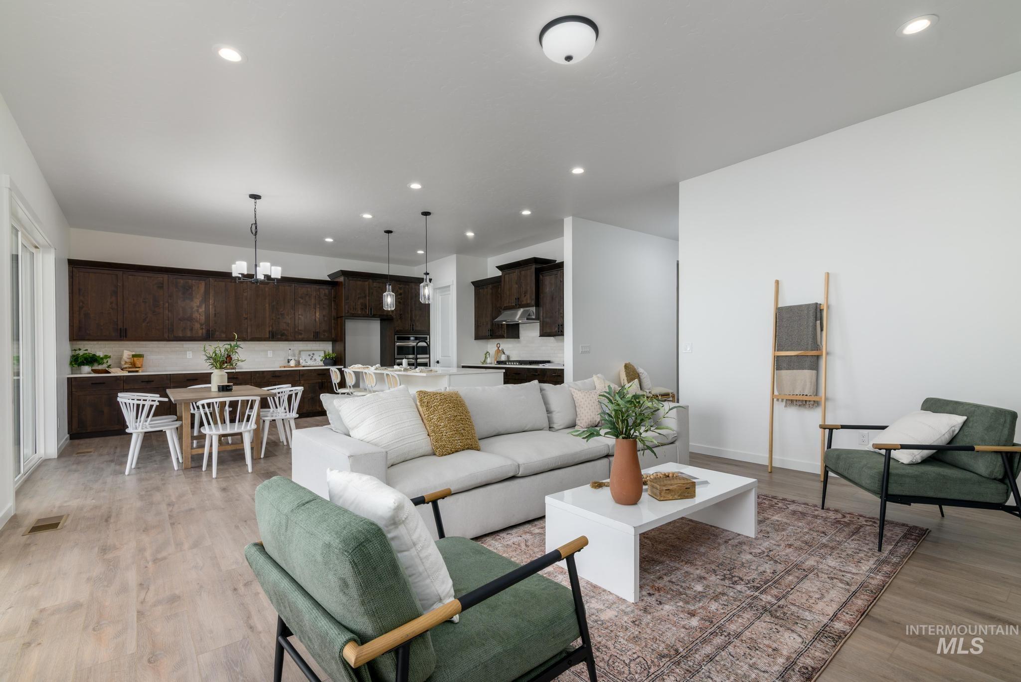 Living room with a chandelier, light wood finished floors, and recessed lighting