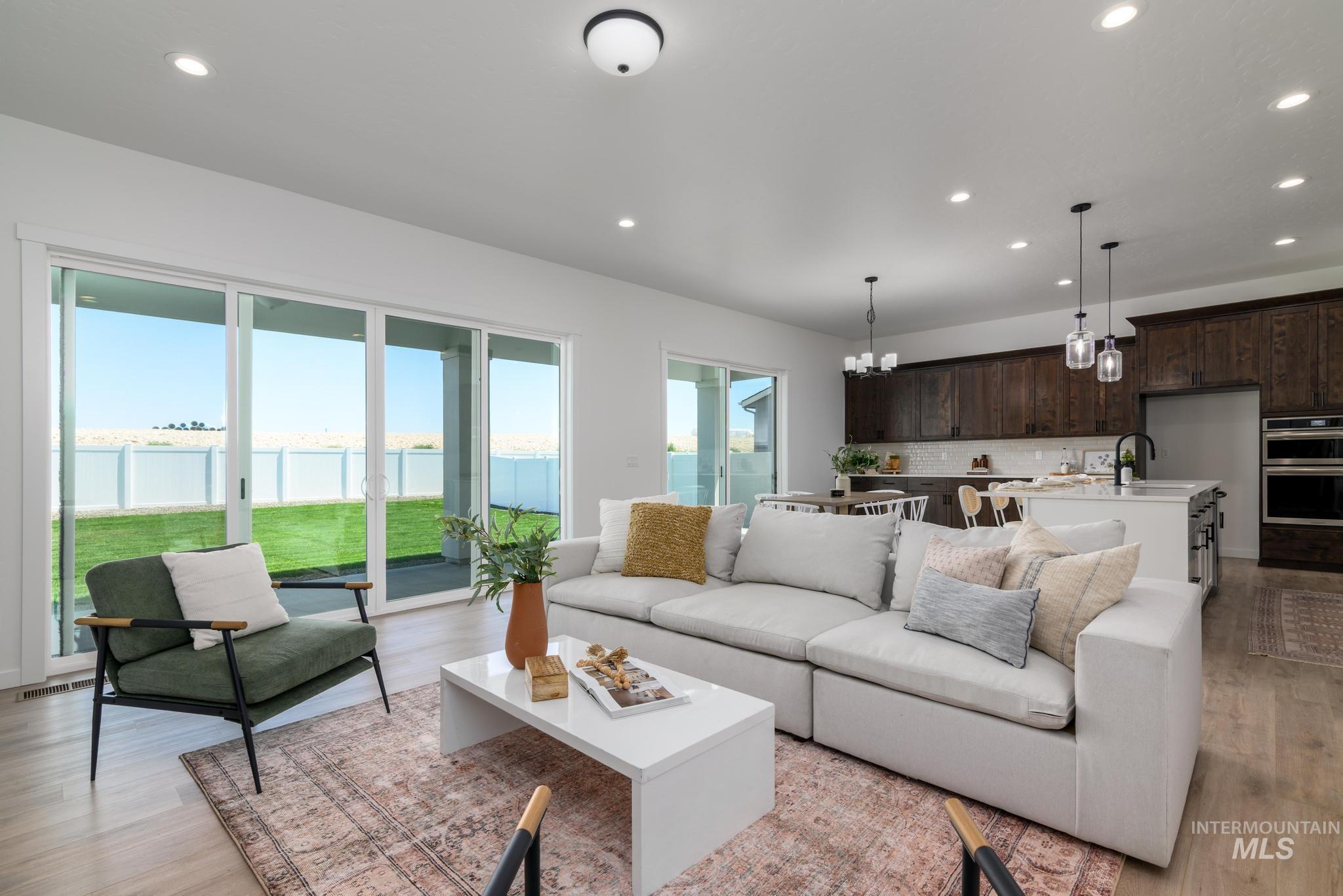 Living area featuring a water view, recessed lighting, light wood-type flooring, and a chandelier