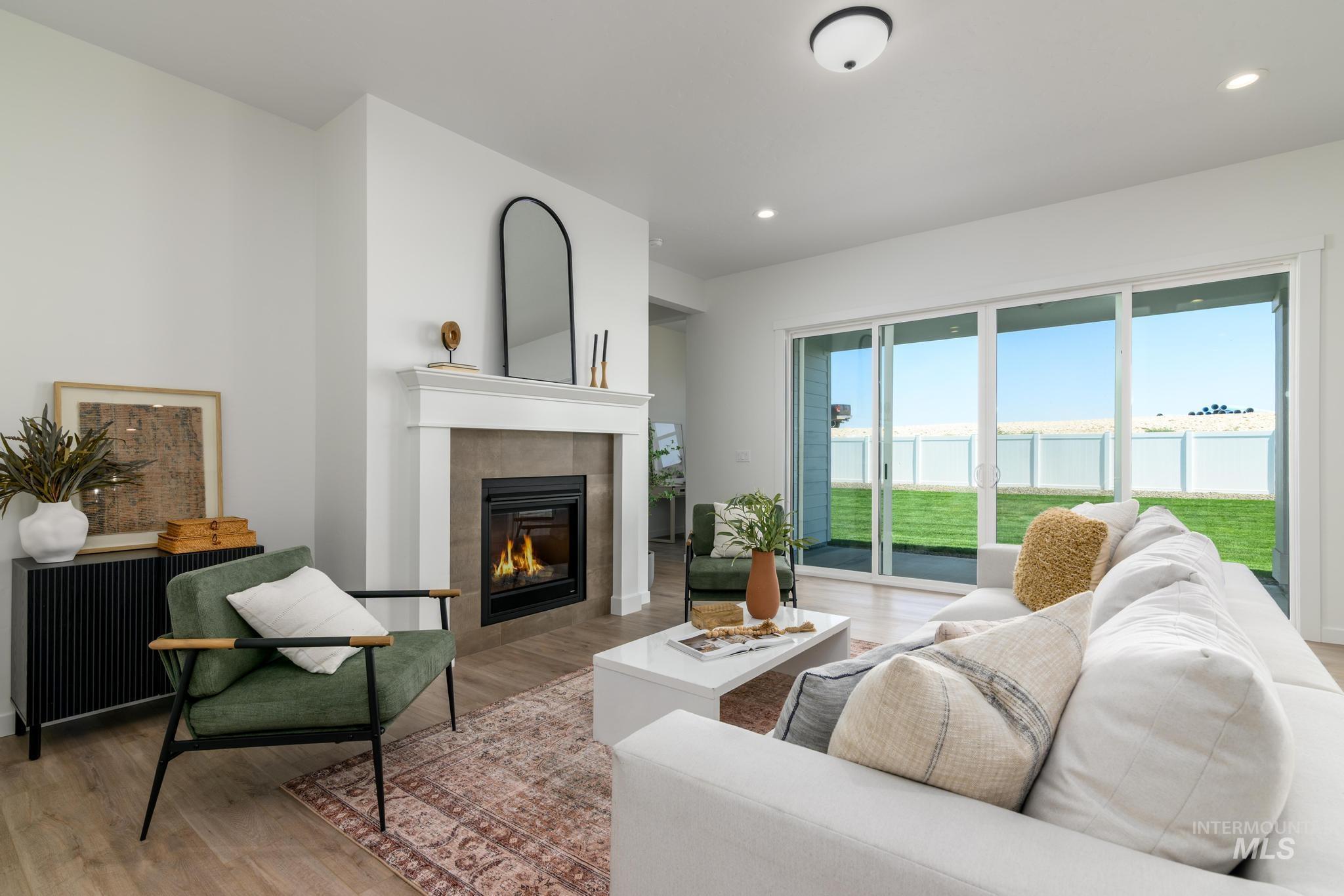 Living area with light wood-style flooring, a fireplace, and recessed lighting