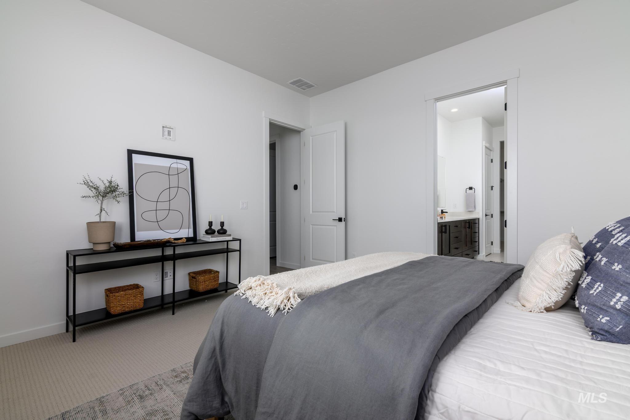 Carpeted bedroom featuring baseboards and ensuite bath