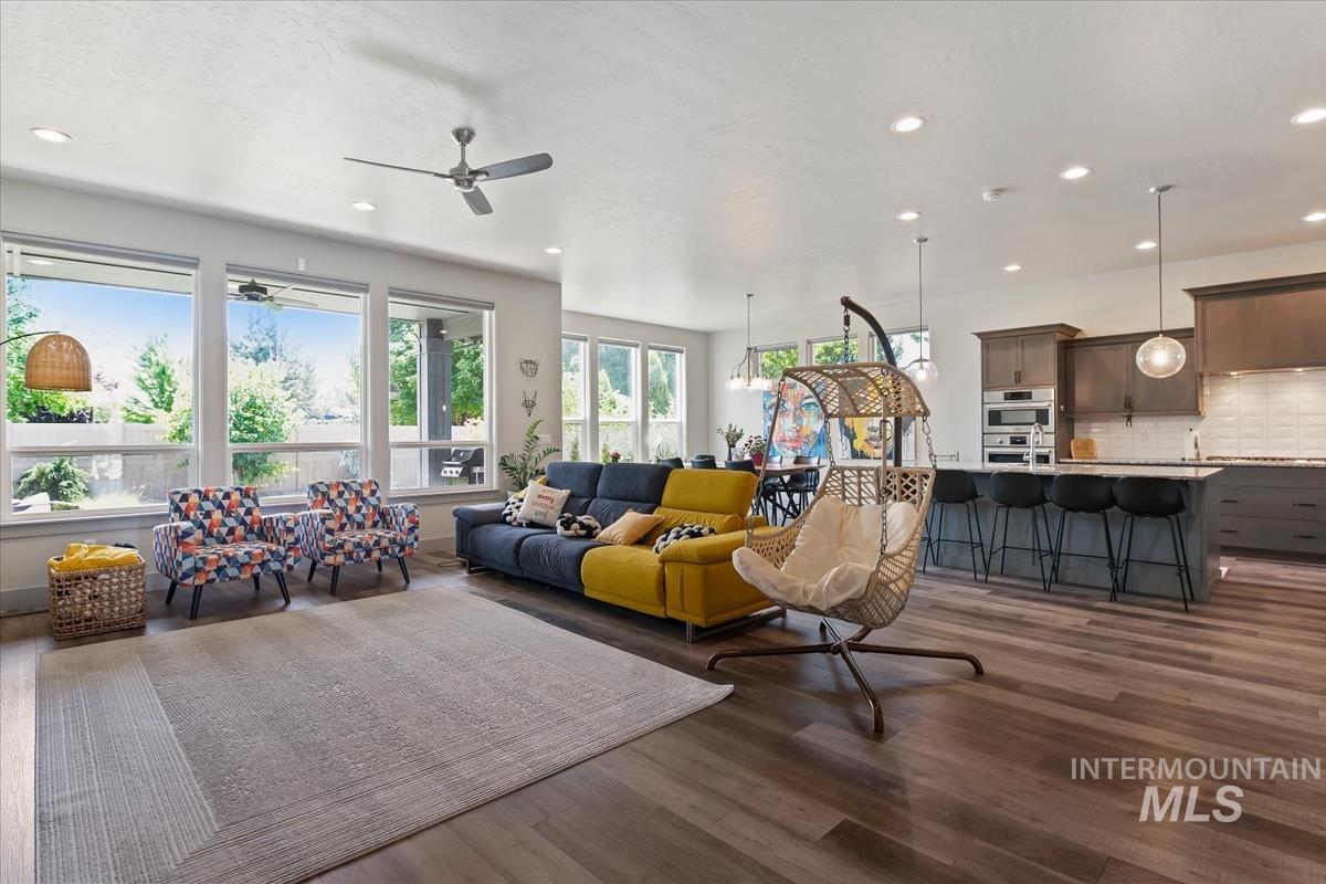 Open-concept living space featuring wood-finish flooring, recessed lighting, and a ceiling fan