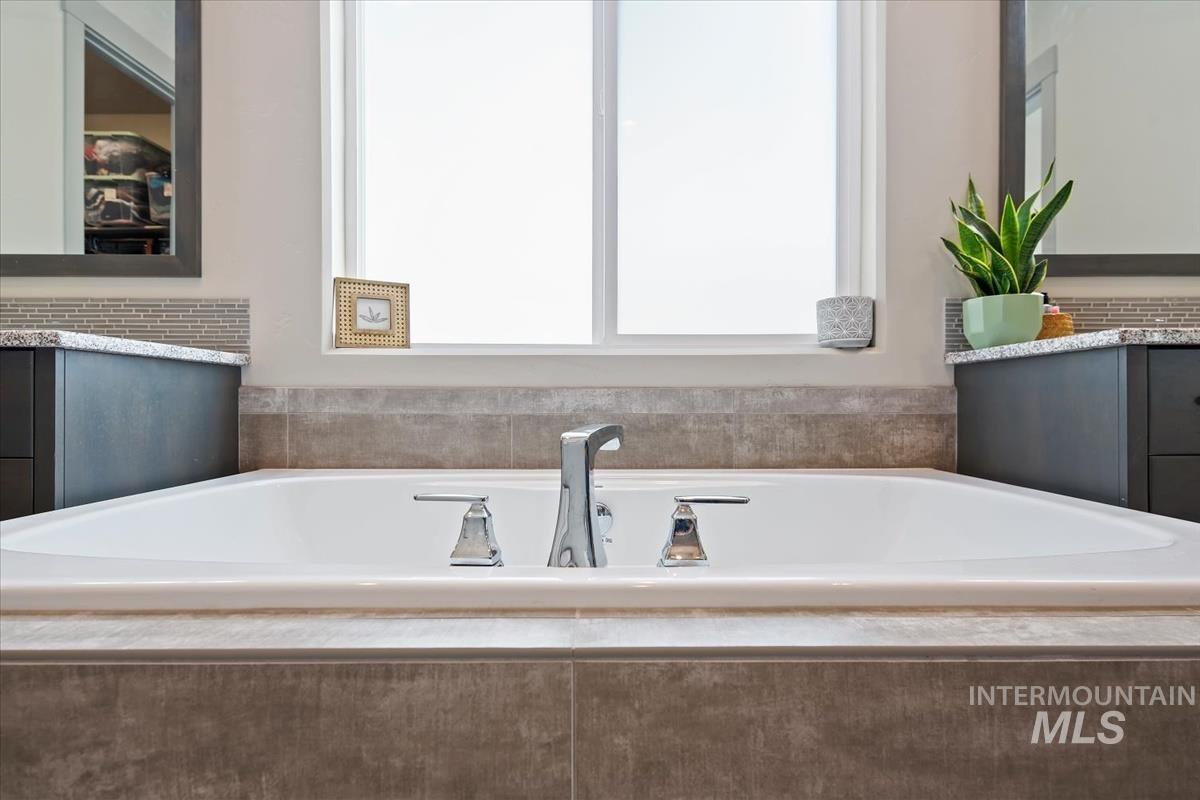 Built-in soaking tub with chrome fixtures and surrounding tilework